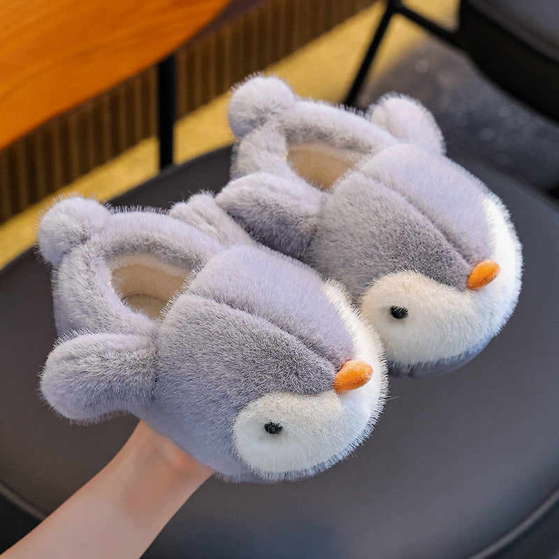 Pair of grey penguin-themed slippers on a chair
