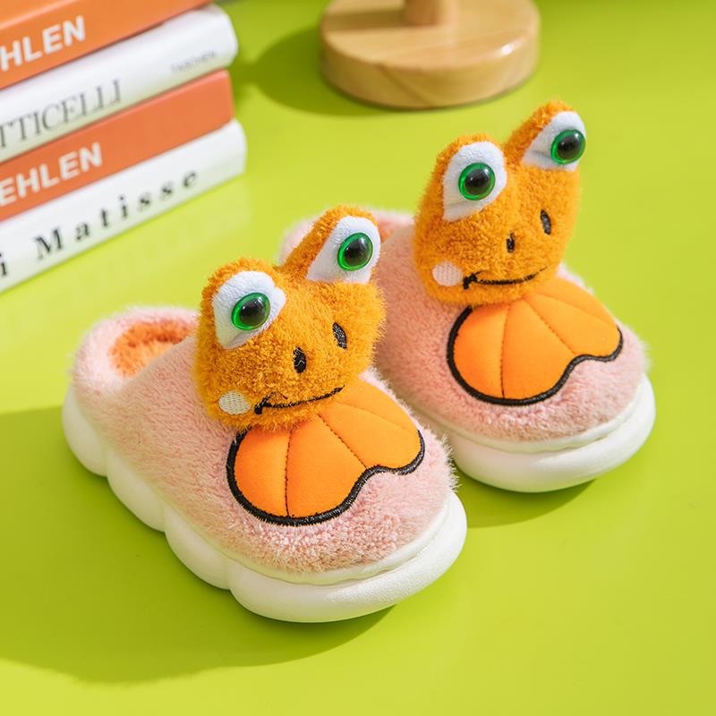 Pair of children's frog shoes on a green surface