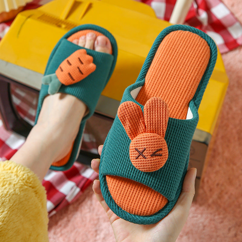 Three colorful children's and Adult bunny and rabbit slippers on a checkered fabric background