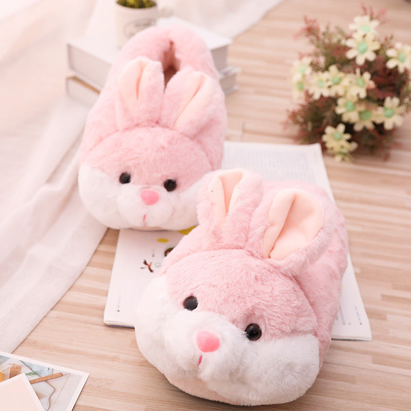Pair of pink bunny slippers on a wooden surface with a light background