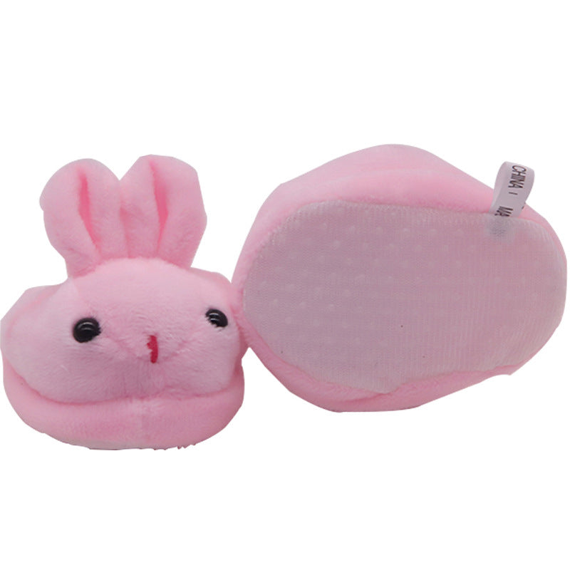 Pink plush slippers shaped like a rabbit on a white background