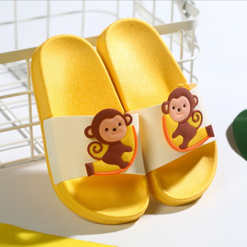 Yellow slippers with monkey design on a white background
