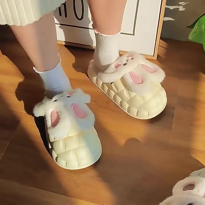 White bunny slippers worn indoors on a wooden floor
