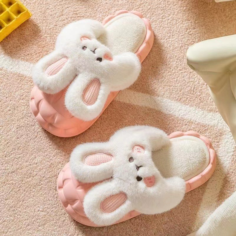 Pair of pink bunny slippers on a soft pink surface