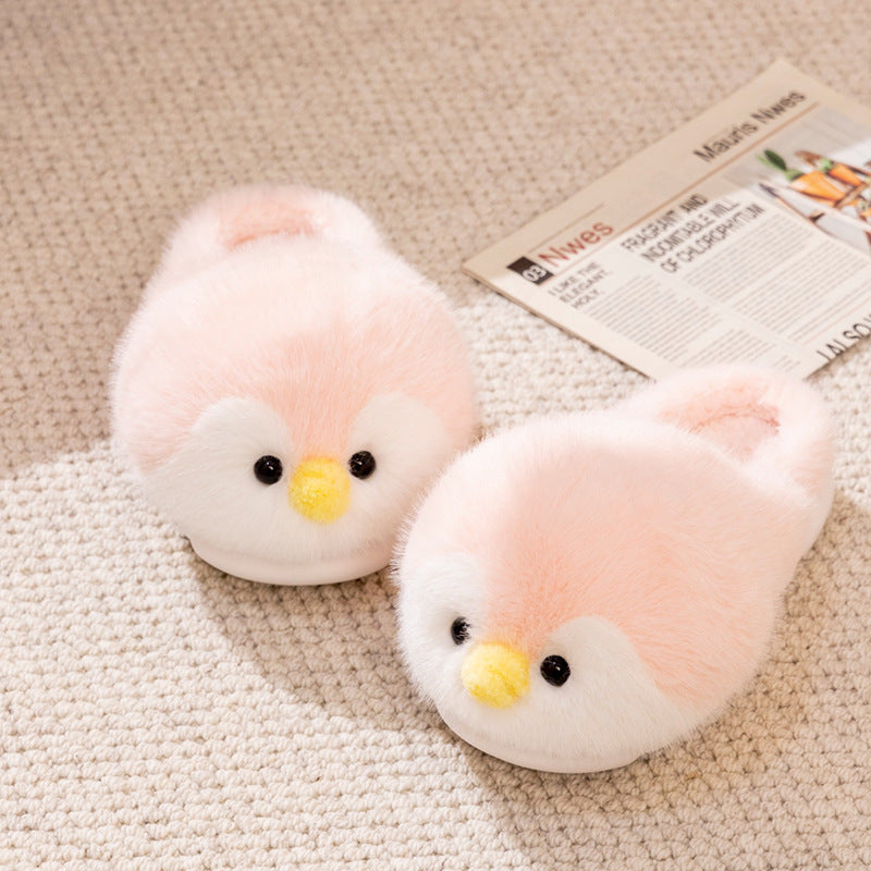  pink plush penguin slippers on a textured surface with a newspaper in the background.