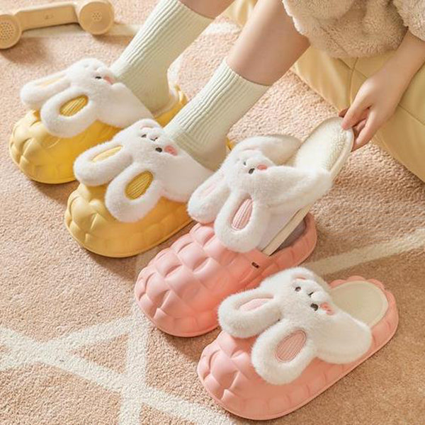 Pair of bunny-shaped slippers on a beige background