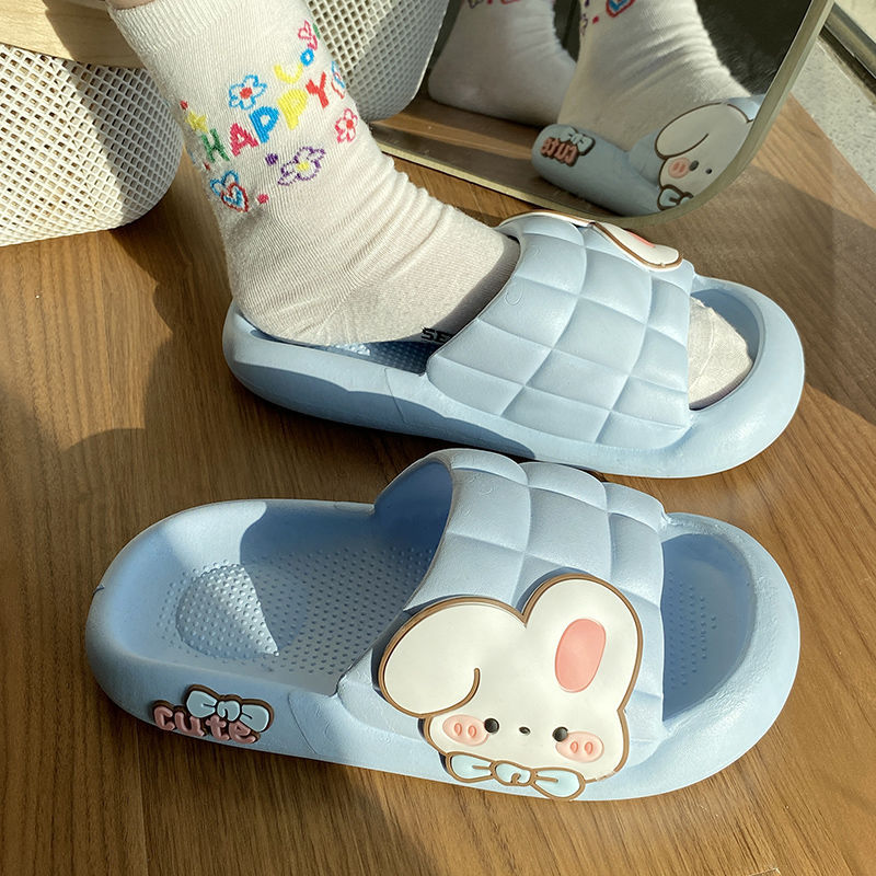 Purple slippers with cartoon bunny design on a wooden surface