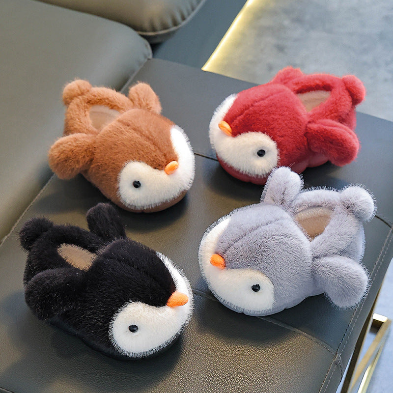 Four plush slippers shaped like animals on a gray surface.