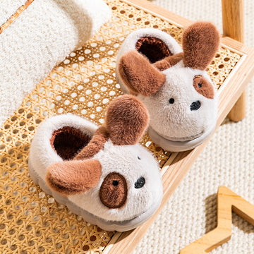 Pair of dog-shaped slippers on a woven surface
