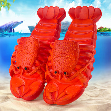 Red lobster-shaped slippers on a beach with ocean and dolphin background