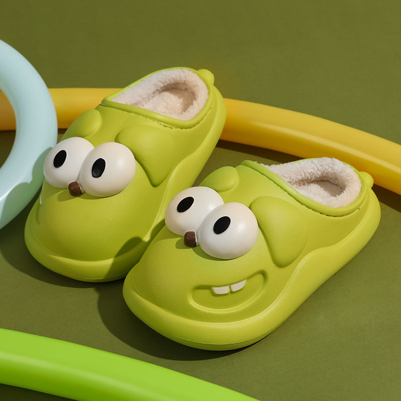 Yellow slippers with cartoon face dog design on a green background