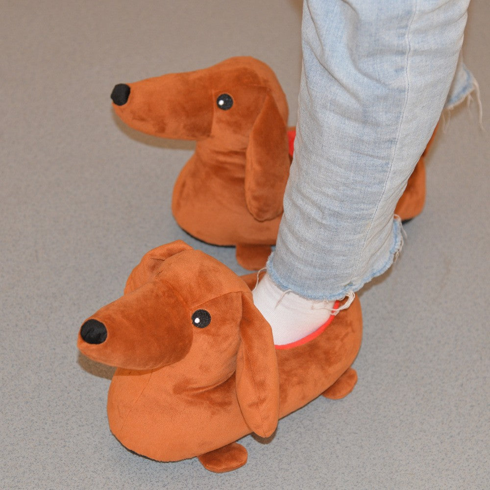 Two brown dachshund-shaped slippers on grass