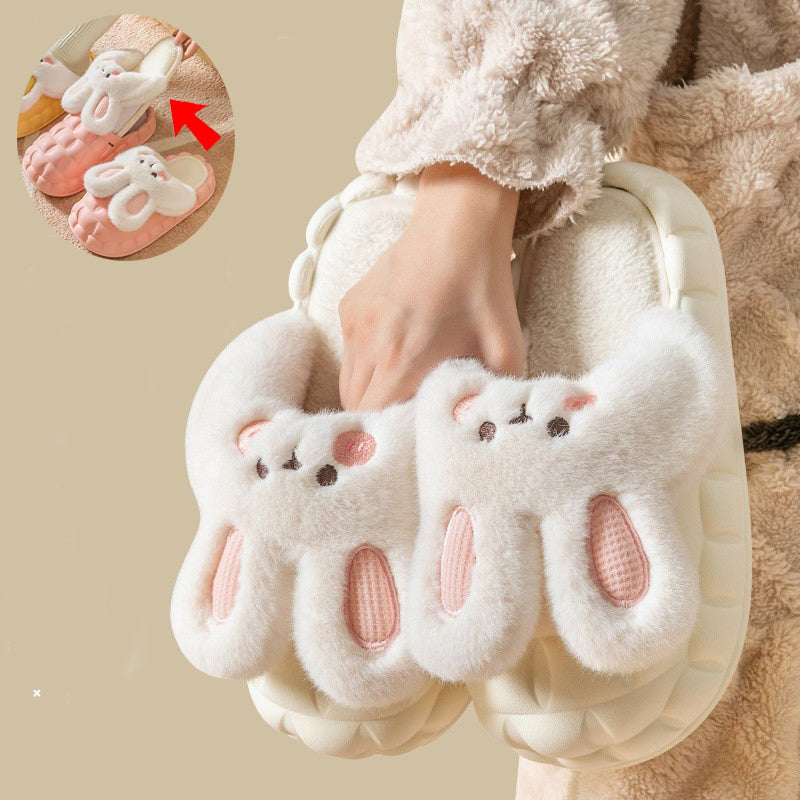 White fluffy slippers with rabbit  cartoon face design worn by a person, with a close-up inset showing the sole.