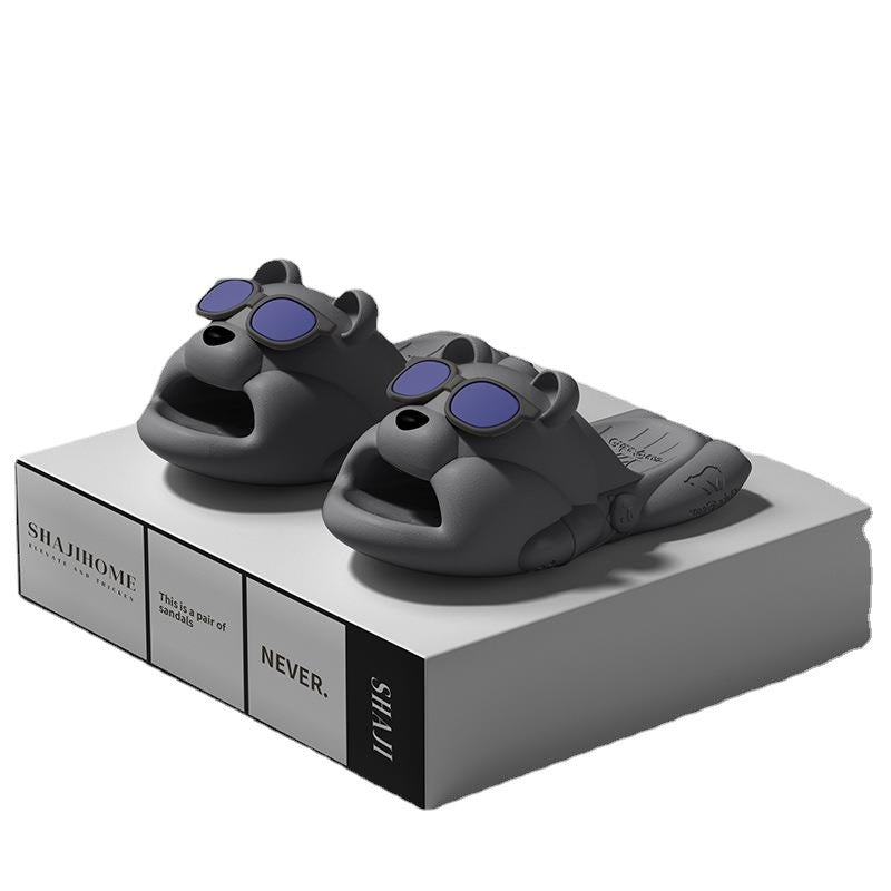 Pair of black animal slippers with purple accents on a white platform, featuring the brand 'JUHU'.
