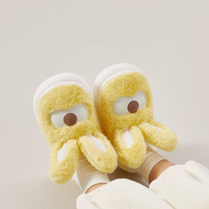 Pair of yellow plush rabbit and bunny slippers with cartoon face design on a light gray background