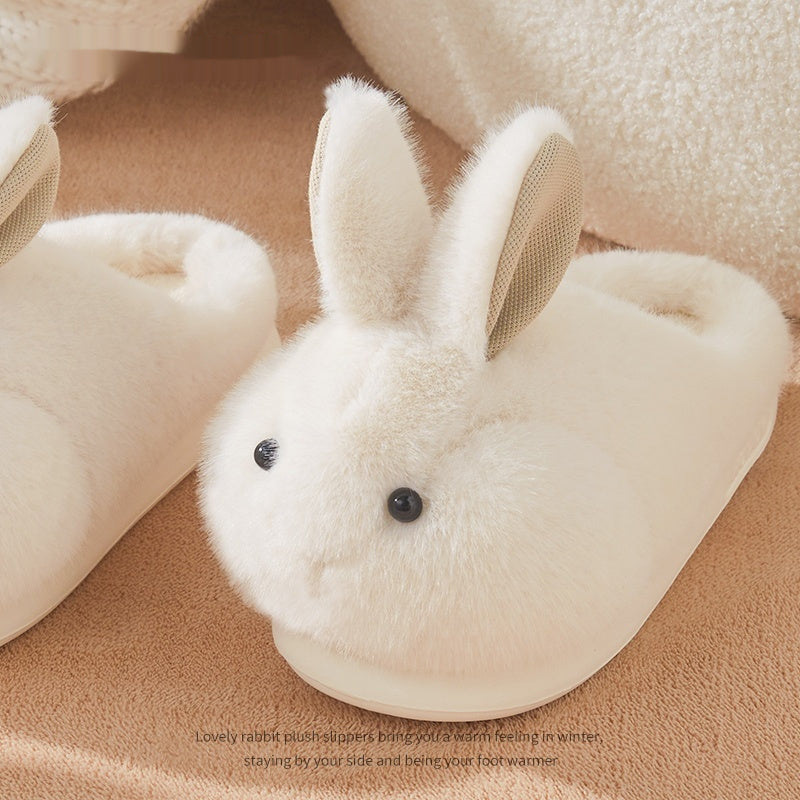 White rabbit-shaped plush slippers on a brown surface