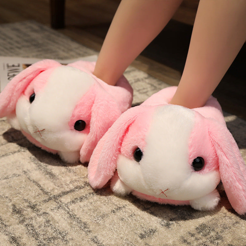 Pink bunny slippers worn by a person on a textured floor.