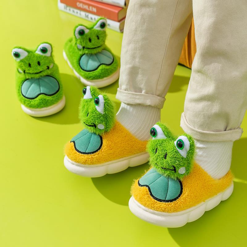Children's frog-themed shoes on a bright green floor