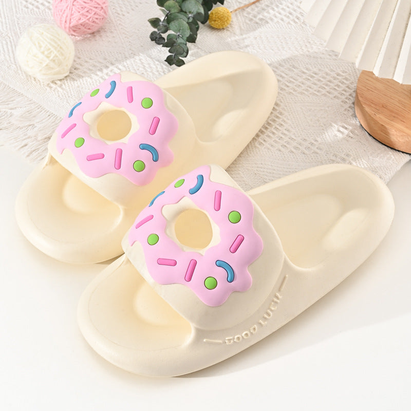 Beige slippers with brown donut design on a white surface