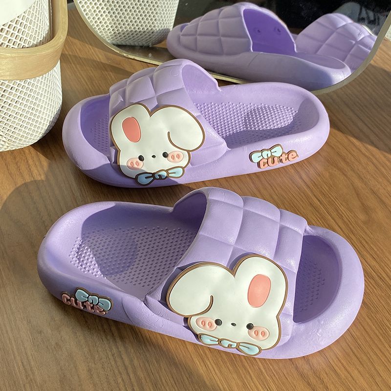 Purple slippers with cartoon bunny design on a wooden surface