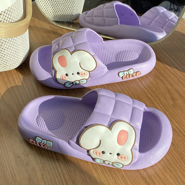 Purple slippers with cartoon bunny design on a wooden surface