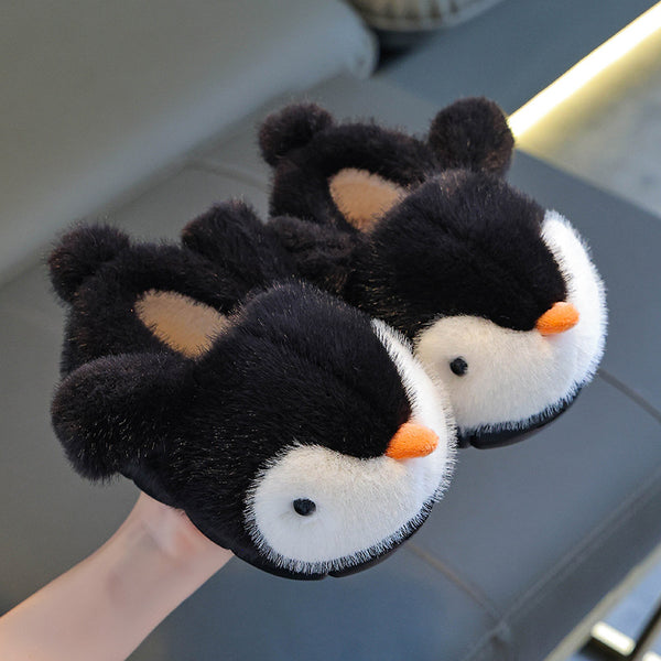Pair of penguin-themed slippers on a reflective surface