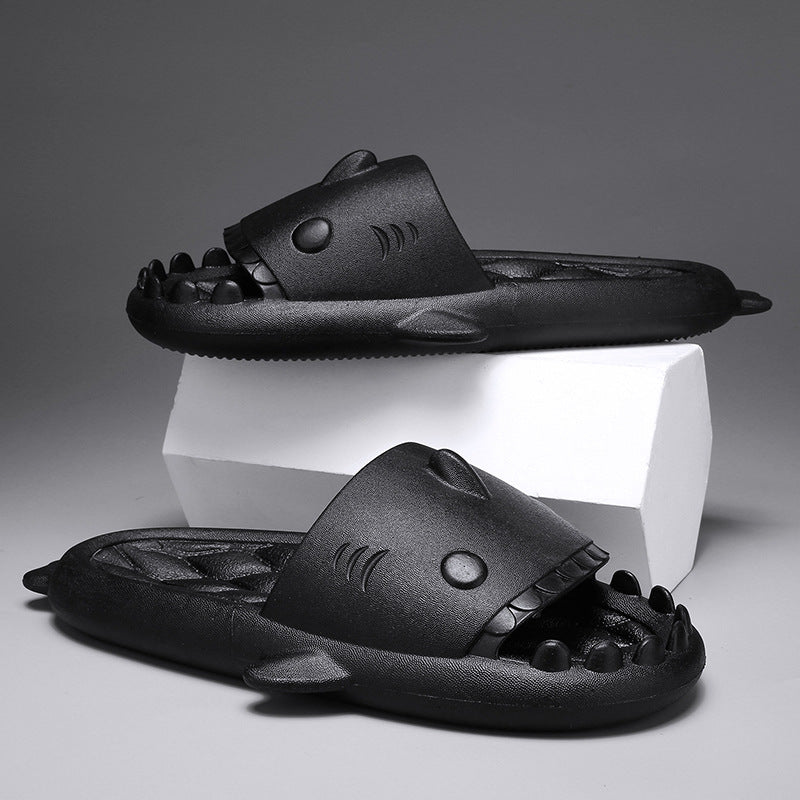 Black shark-shaped slippers on a gray background