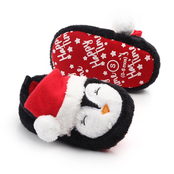 Plush penguin baby slippers with Christmas Cap on a white background