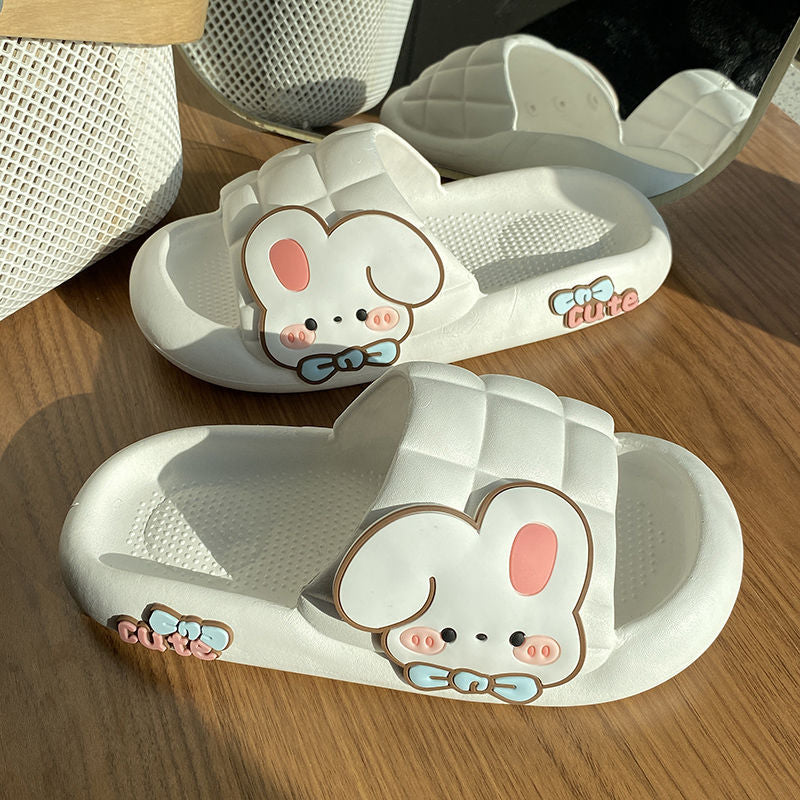 White slippers with cartoon bunny design on a wooden surface