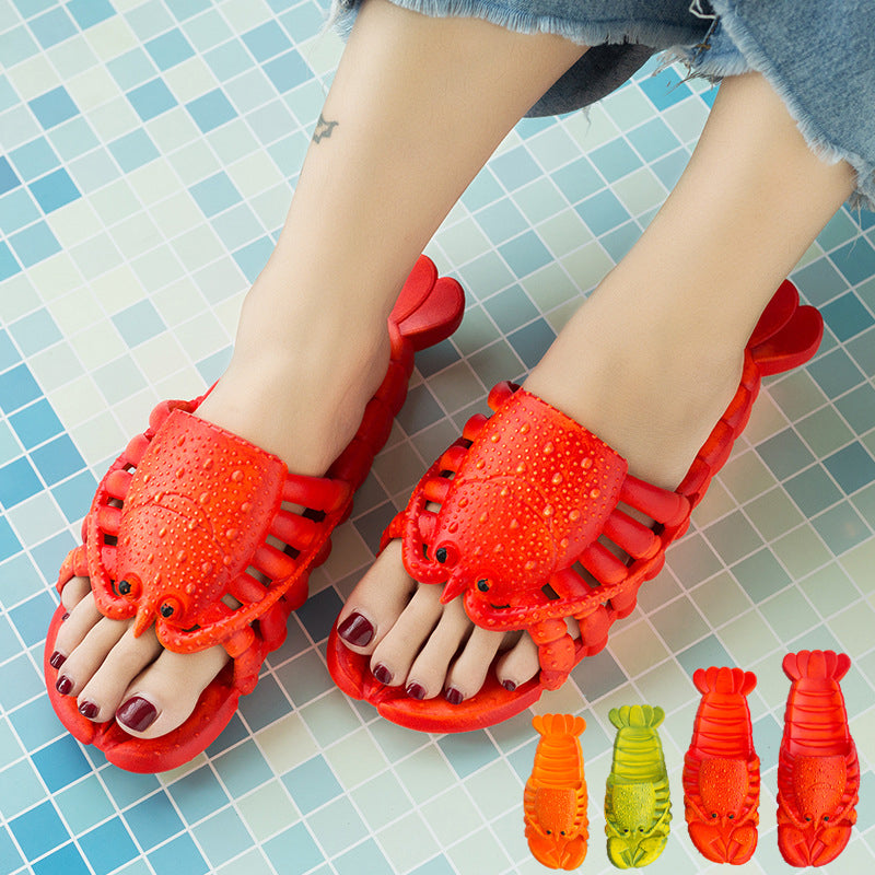 Red lobster-shaped sandals worn on a tiled floor with smaller lobster sandals displayed below.