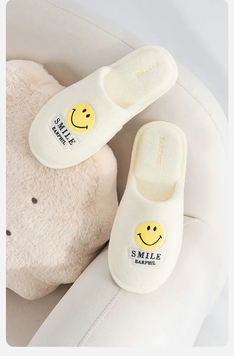 White slippers with smiley face design on a white background