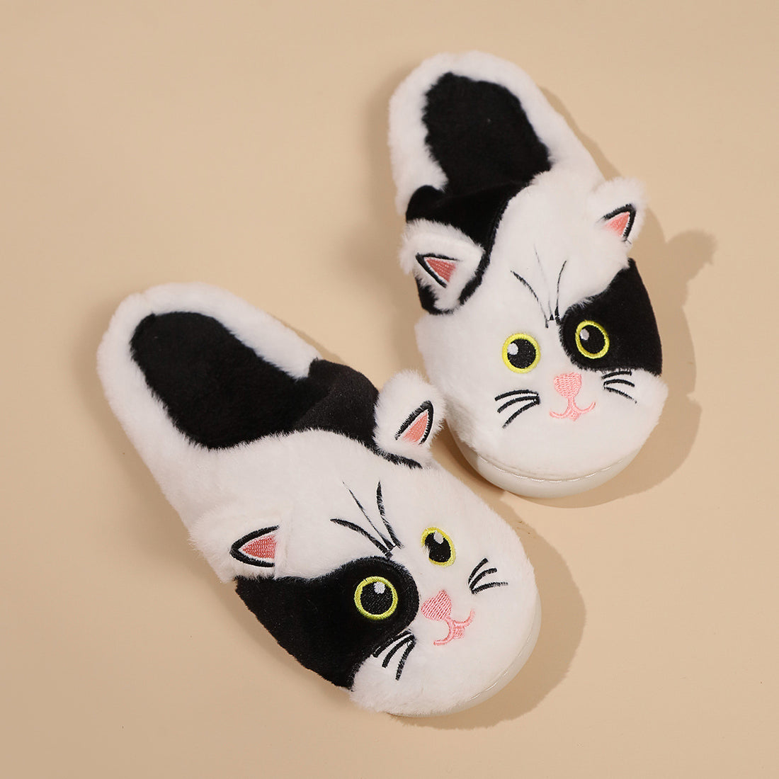 Cat-themed slippers worn by a person on a light background