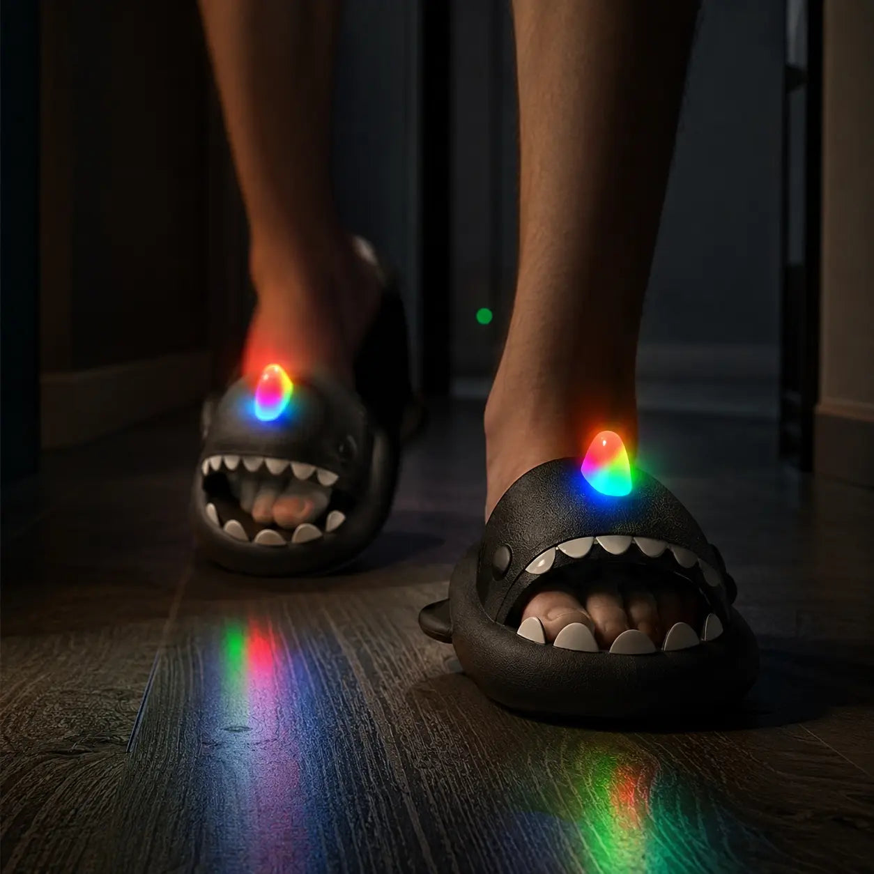 Black shark-shaped slippers with glowing rainbow accents on a wooden floor.