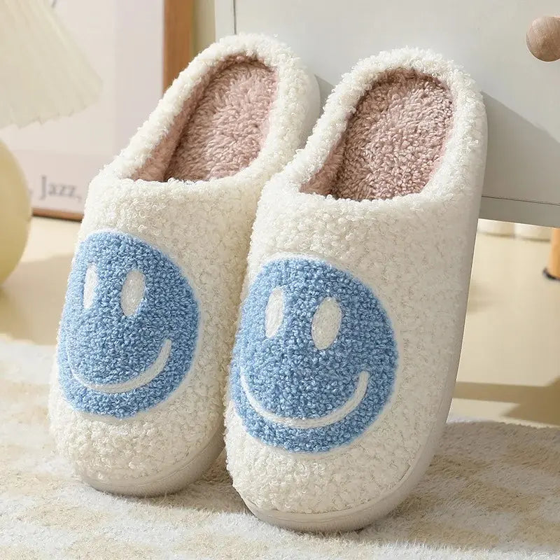 White slippers with blue smiley face design on a light background