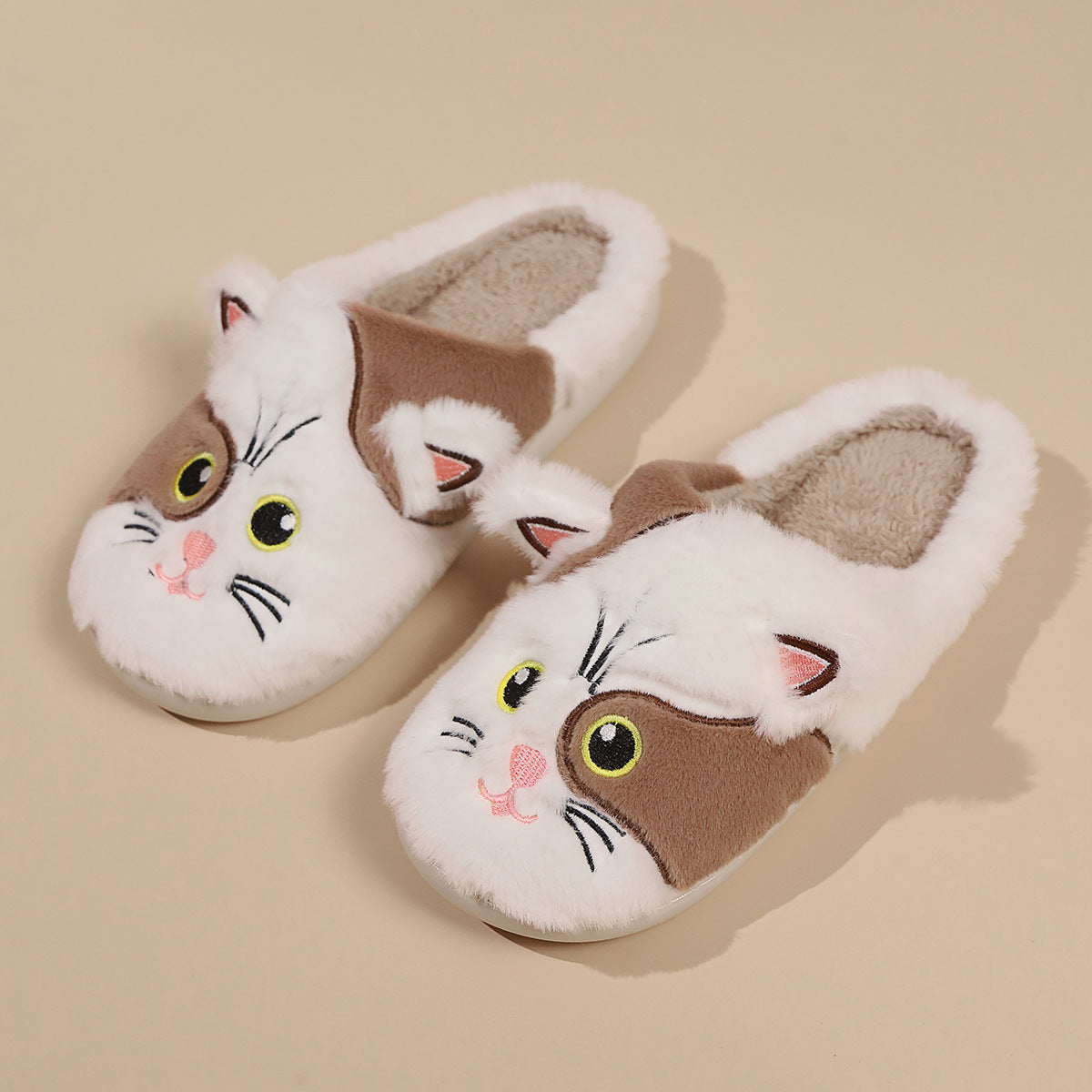Pair of cat-shaped slippers on a beige background