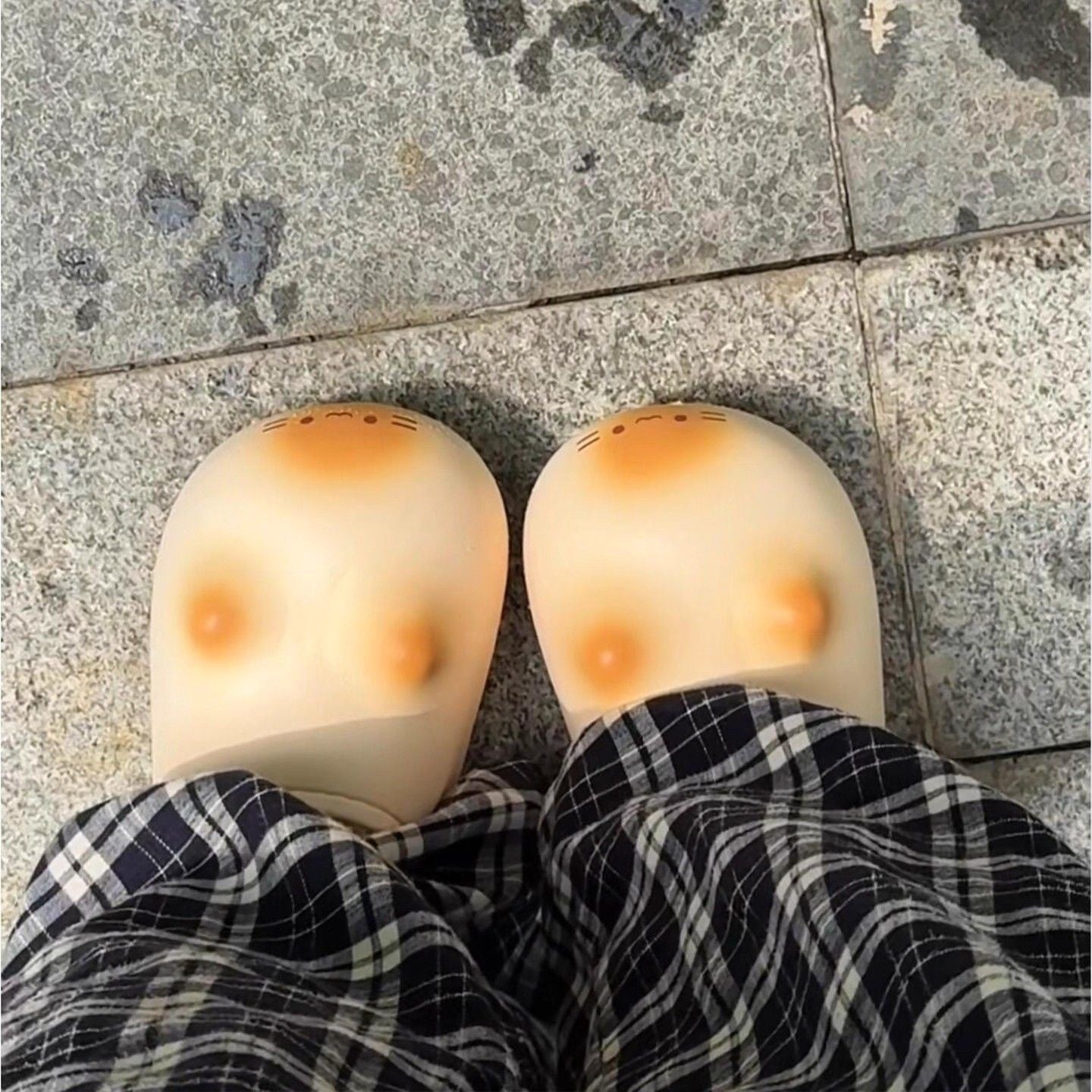 Slippers with cartoonish design on a stone pavement