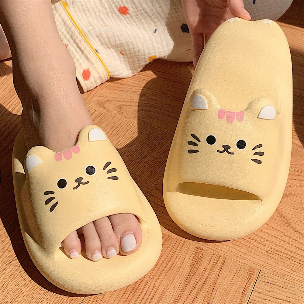 Yellow cat-shaped slippers on a wooden floor