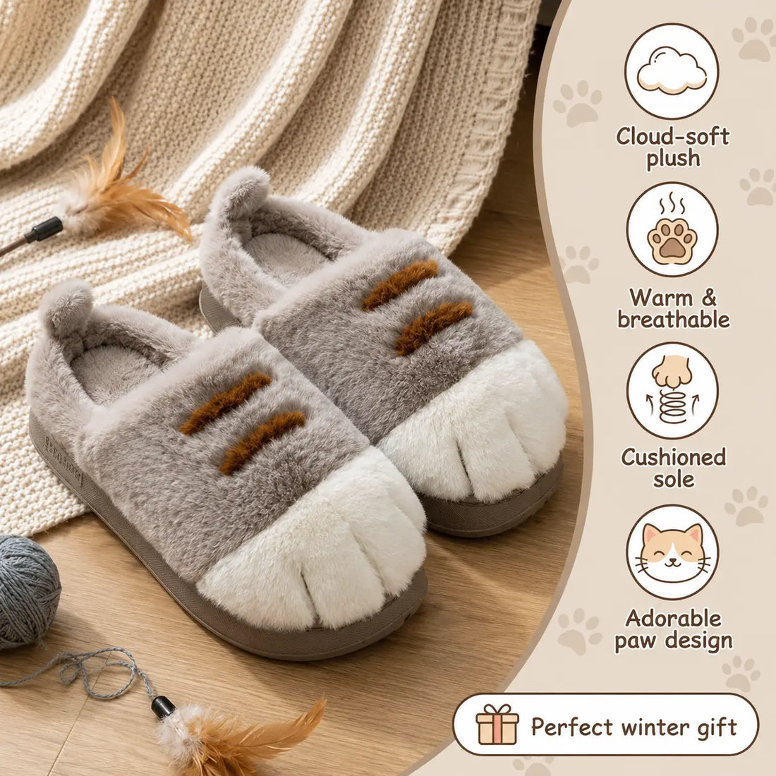 Pair of gray and white slippers with paw design on a wooden surface, surrounded by yarn and feathers.