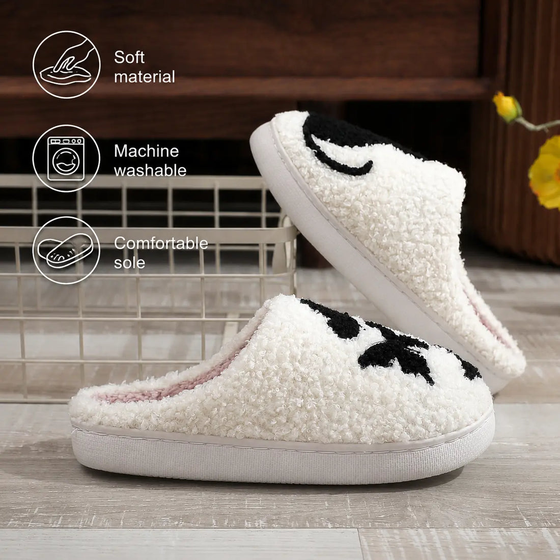 Pair of white slippers with black cat designs on a rug in front of a fireplace.