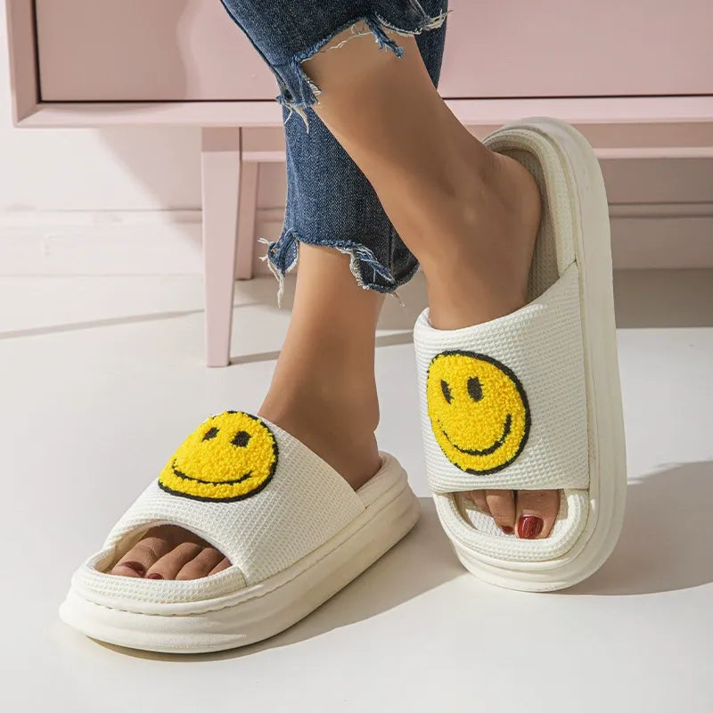 White slides with smiley face design worn by a person on a light background