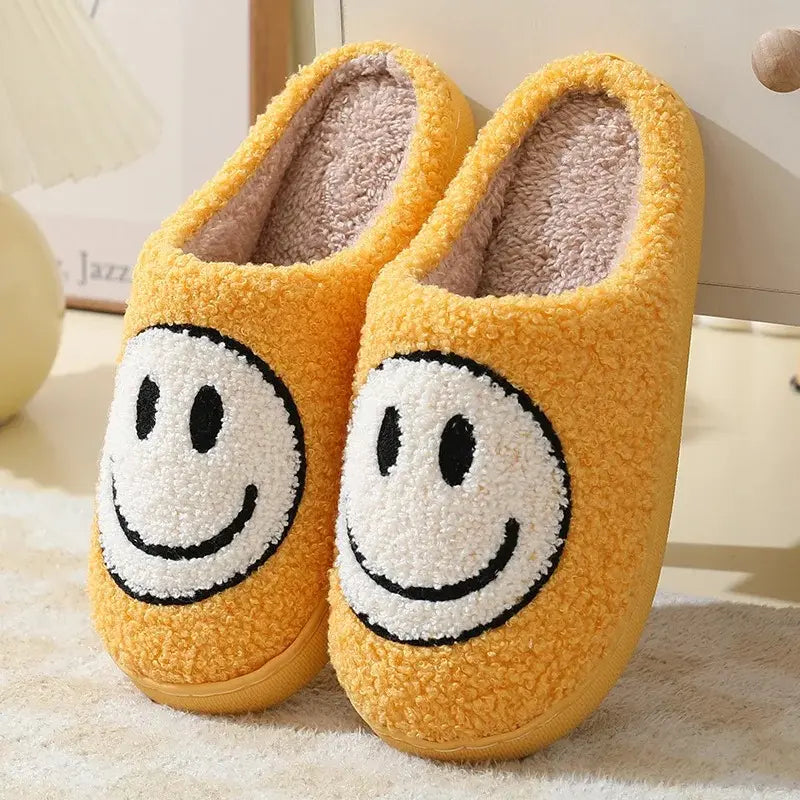 Yellow slippers with smiley face design on a soft surface