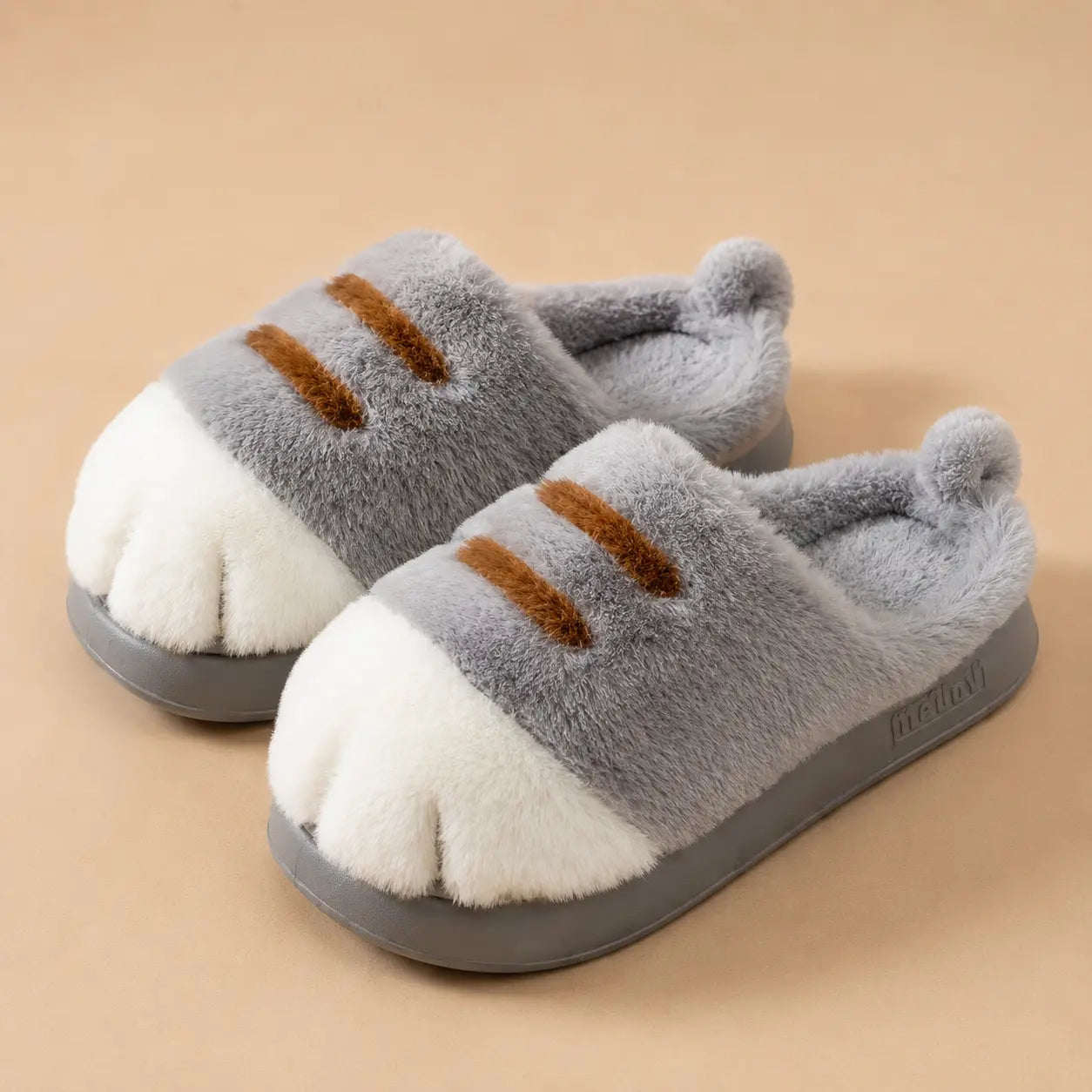Pair of gray and white slippers with brown accents on a beige background