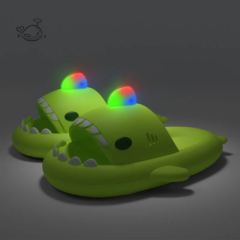 Green crocodile-shaped slippers with colorful LED lights on a dark background