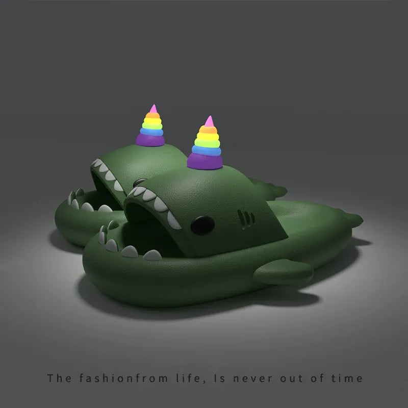 Green shark-shaped slippers with rainbow horns on a dark background