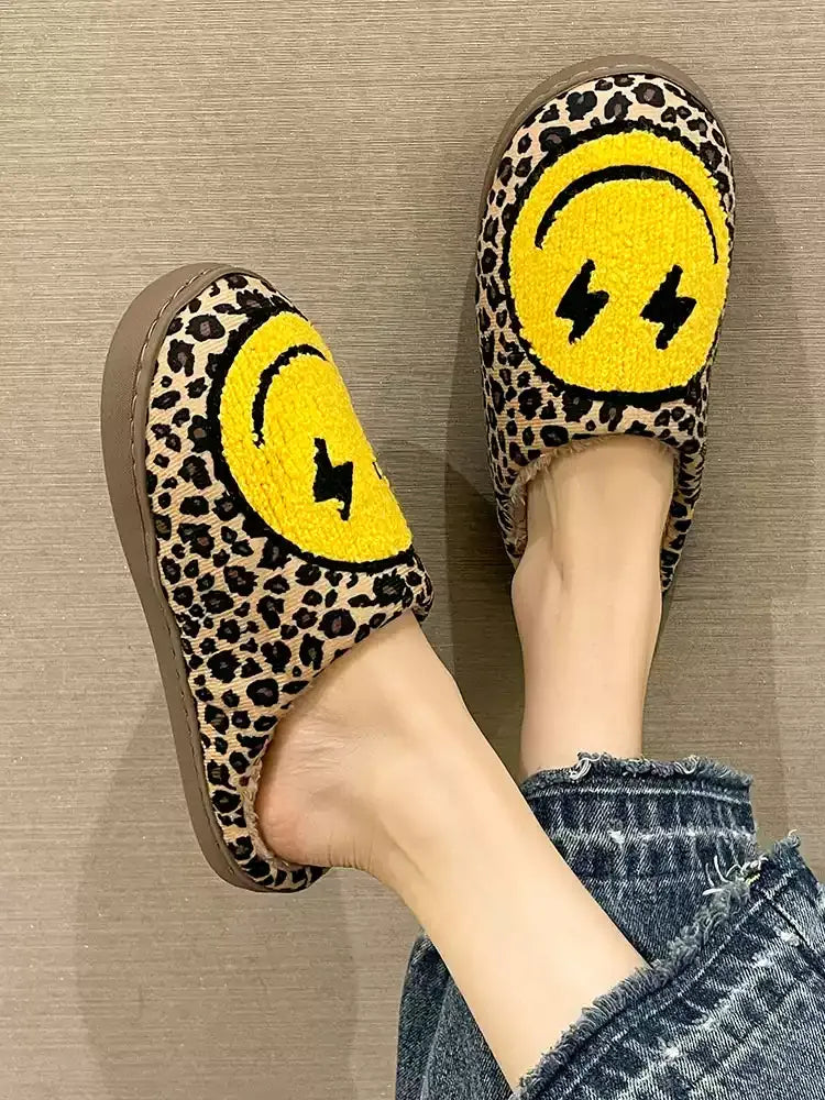 Leopard print slippers with yellow smiley face design worn indoors.