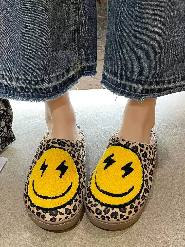 Leopard print slippers with smiley face design worn with jeans.