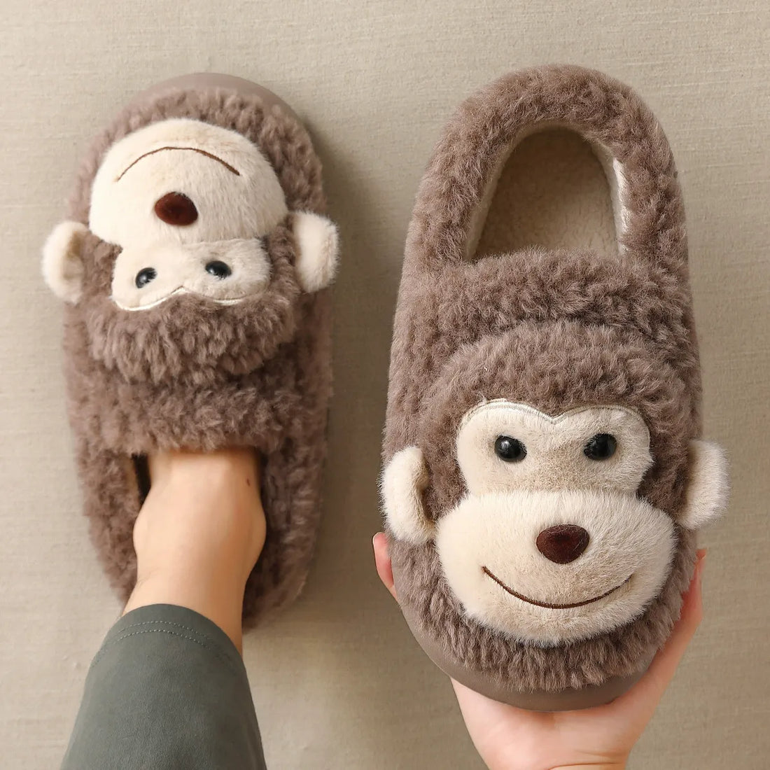 Monkey-themed slippers with a person wearing them on a neutral background