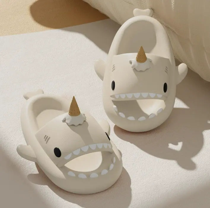 Two white sandals with unicorn design on a light background