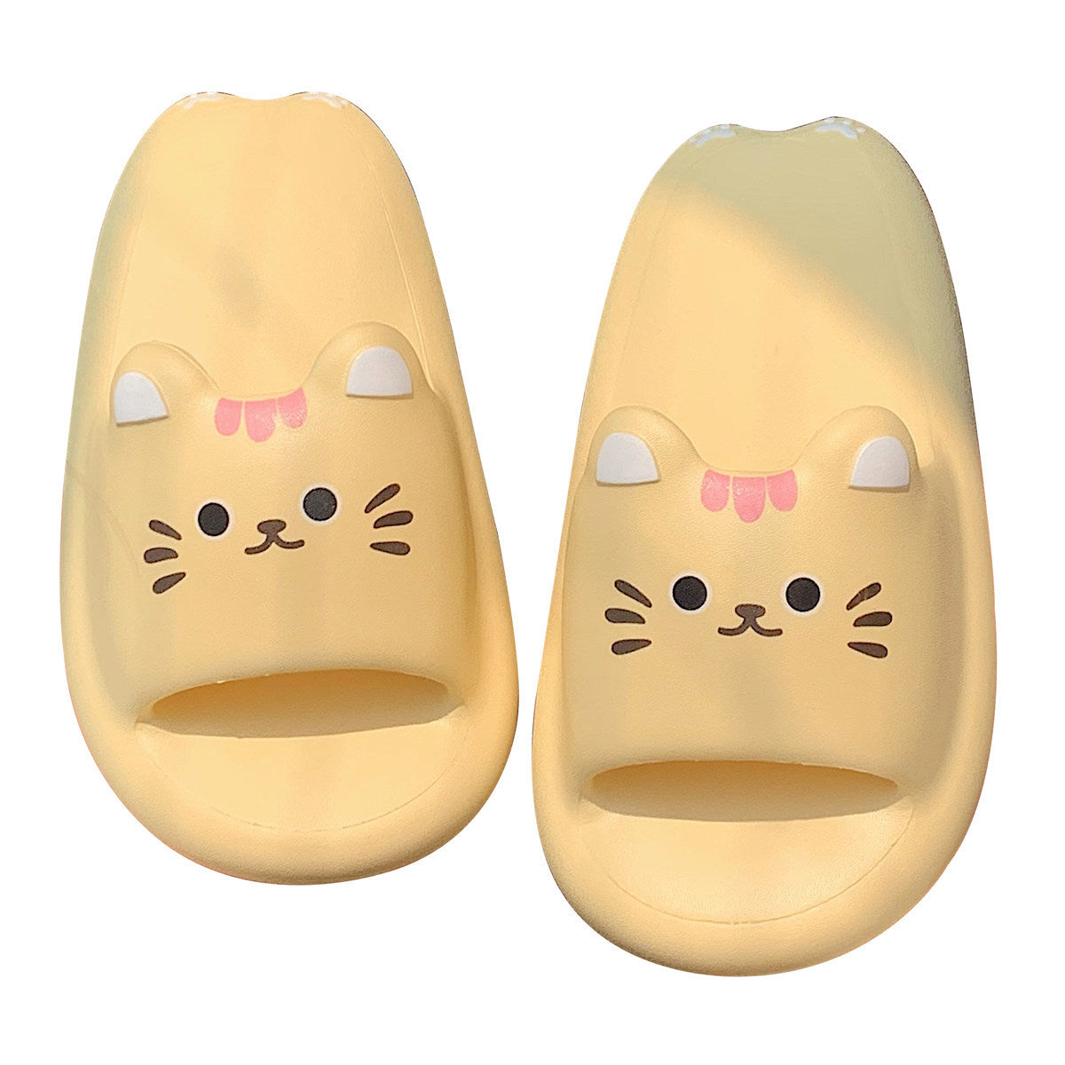 Pair of yellow cat-shaped slippers with cute face design on a white background