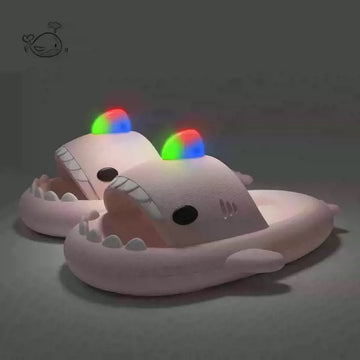 Plush shark toy with glowing rainbow eyes on a dark background